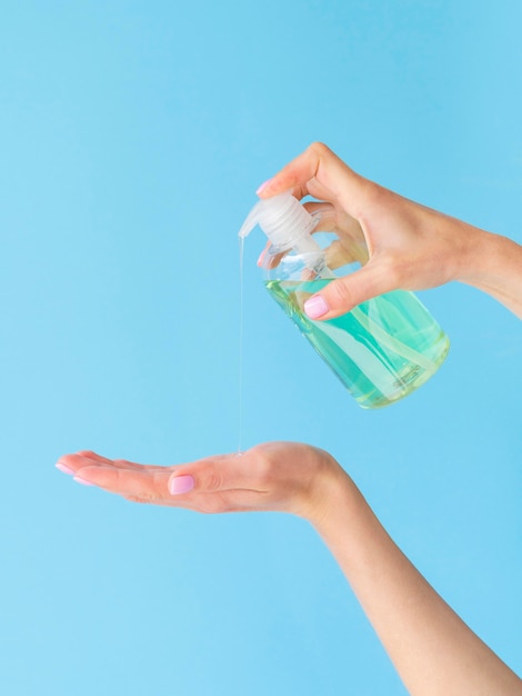 Foto le mani che usano il sapone liquido formano una bottiglia di plastica