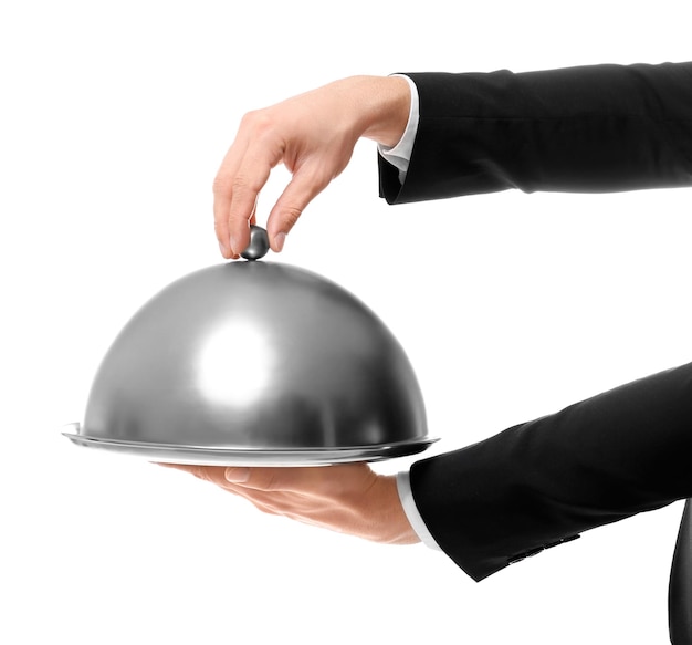 Hands of waiter holding metal tray with cover on white background