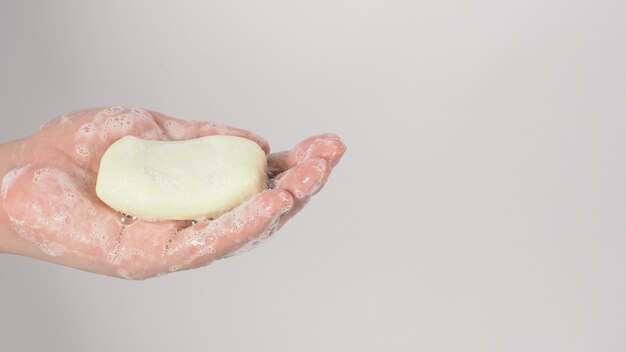 Hands washing gesture with bar soap and bubble on white background.