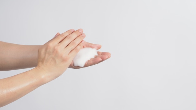 Hands washing gesture with foaming hand soap on white background.