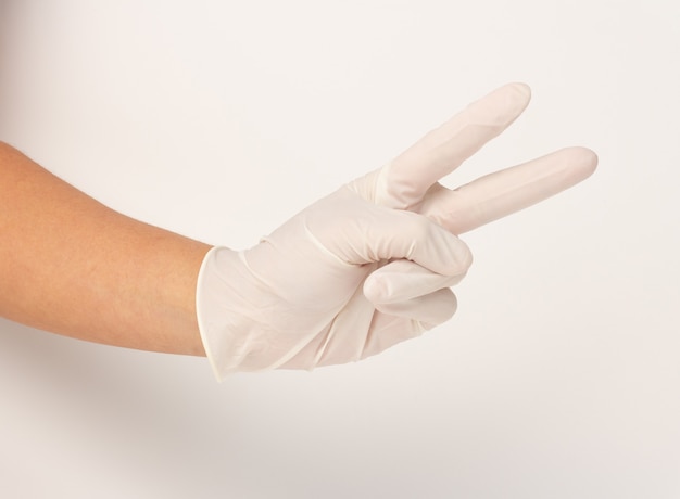 Hands wearing a white rubber gloves and holding two fingers are symbols of encouragement in the fight.