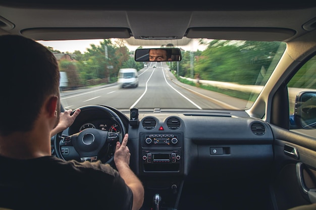 Mani sul volante durante la guida ad alta velocità dall'interno dell'auto