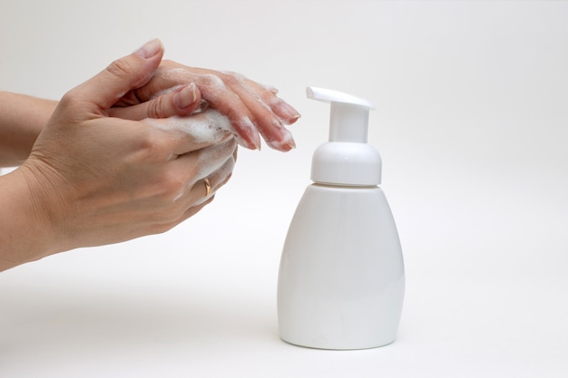 Hands on a white background in white foam from antibacterial soap