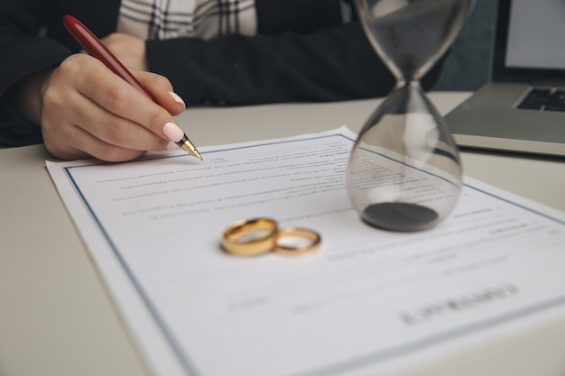 Hands of wife, husband signing decree of divorce, dissolution, canceling marriage, legal separation documents