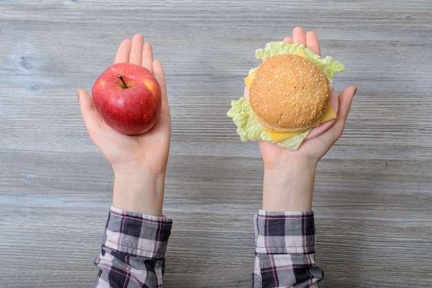 Hands with apple and burger