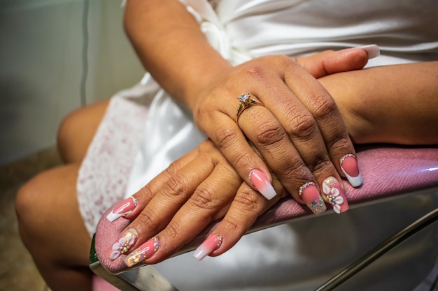 Hands with decorated and painted nails with engagement ring