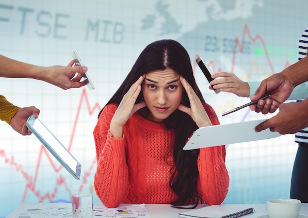 Hands with devices surrounding stressed woman against blue graph