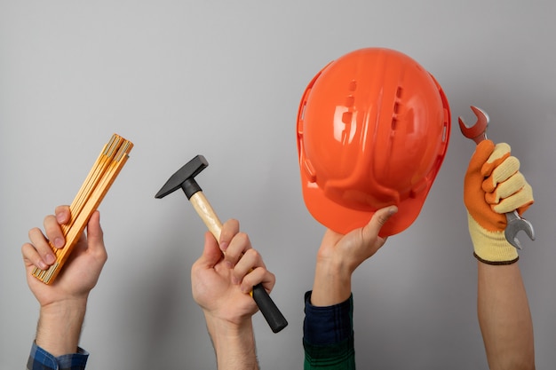 Hands with different construction tools