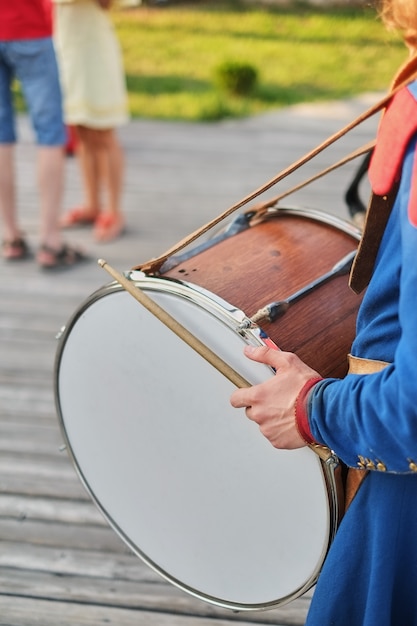 Hands with drum sticks and a big drum National dress