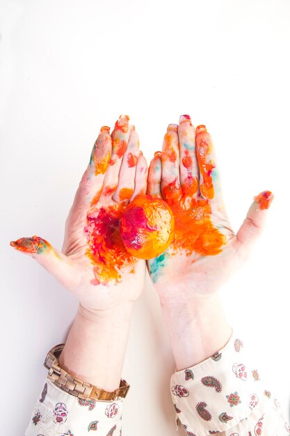 Photo hands with egg stained with paint