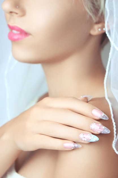 Photo hands with french manicure on a wedding dress