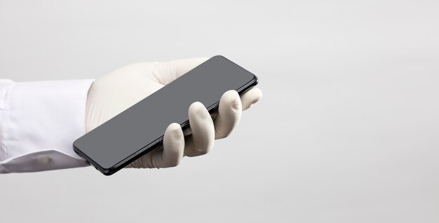 Hands with gloves and phone with gray screen