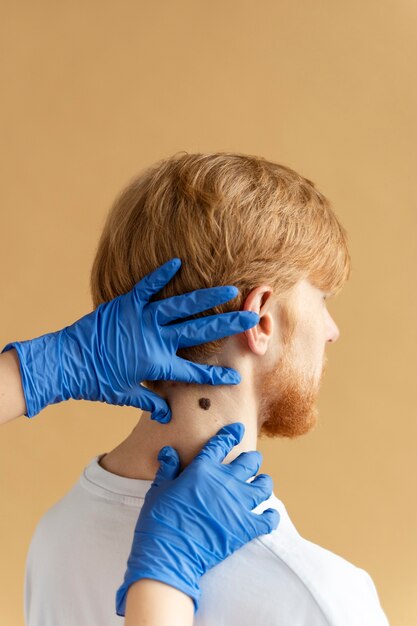 Photo hands with gloves touching man's skin