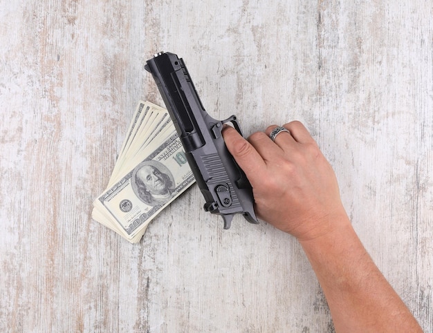 hands with gun and dollars