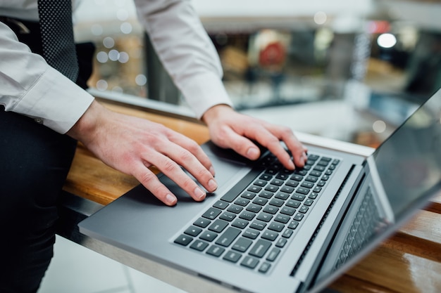 Hands with a laptop at work. Blogger at the coffee shop. Business man