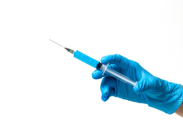 Hands with latex gloves and syringe preparing the coronavirus vaccine