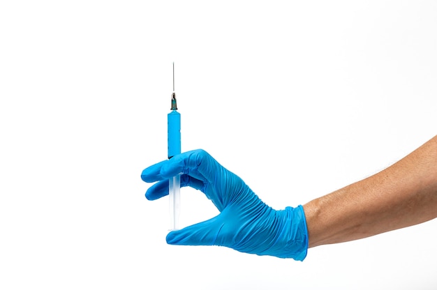 Hands with latex gloves and syringe preparing the coronavirus vaccine