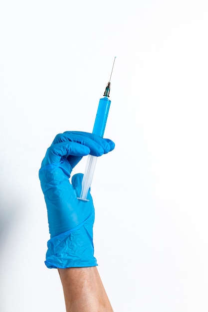 Hands with latex gloves and syringe preparing the coronavirus vaccine