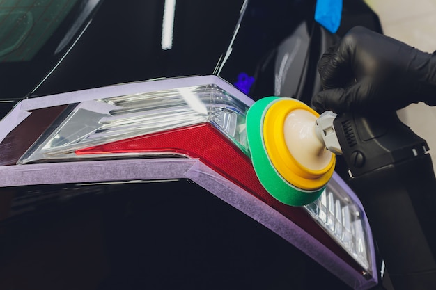 Photo hands with orbital polisher in auto repair shop.