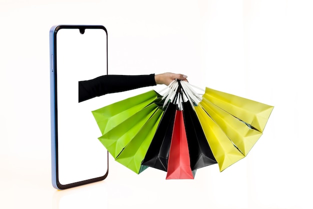 Photo hands with paper shopping bags outstreched from cellphone screen towards copy space white background isolated creative image for delivery service mobile application concept