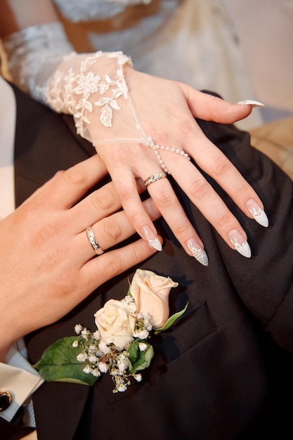 Hands with rings on wedding bouquet