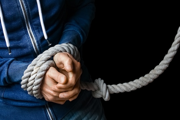 Hands with a rope on a black background