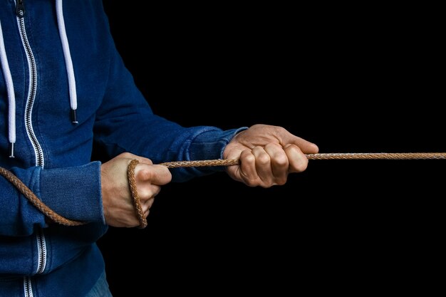 Hands with a rope on a black background