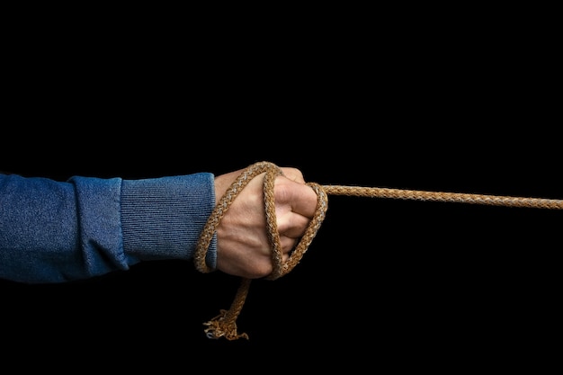 Hands with a rope on a black background