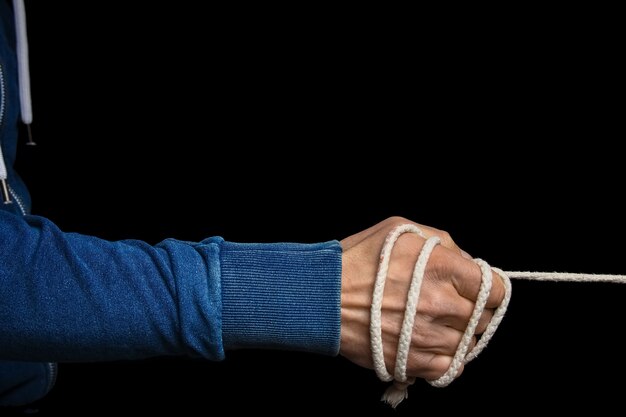 Photo hands with a rope on a black background