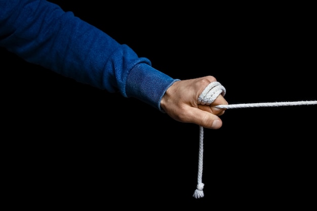 Hands with a rope on a black background