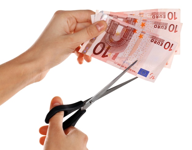 Hands with scissors cutting Euro banknotes isolated on white