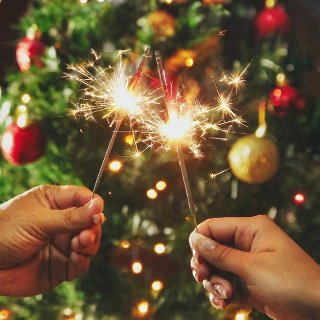 Photo hands with shiny sparks and details and background christmas decoration