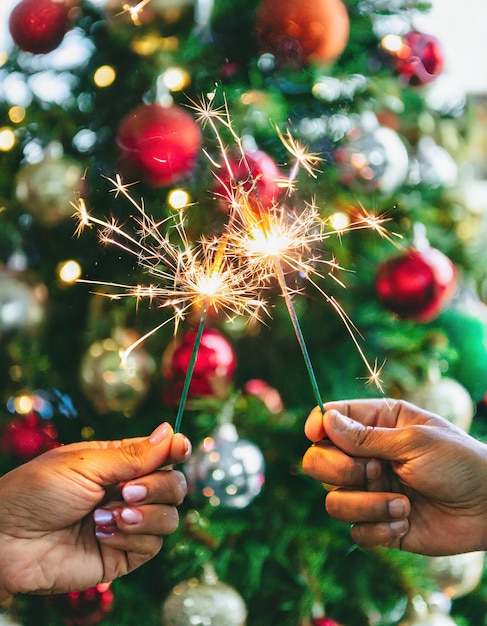 hands with shiny sparks and details and background christmas decoration