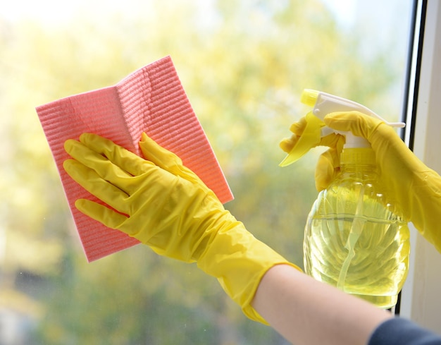 Photo hands with spray cleaning the window