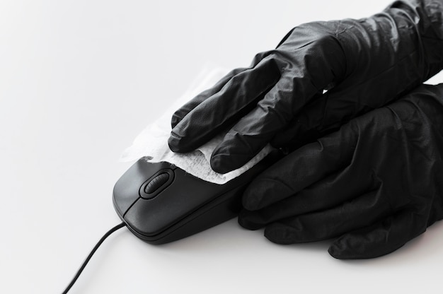 Photo hands with surgical gloves disinfecting mouse