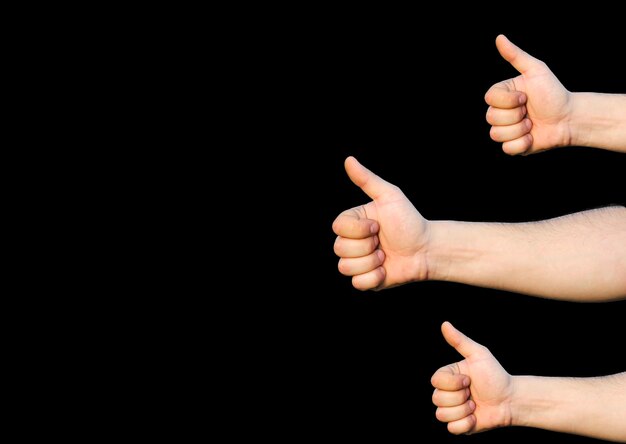 Hands with thumbs up. Like sign. Isolated on black background.