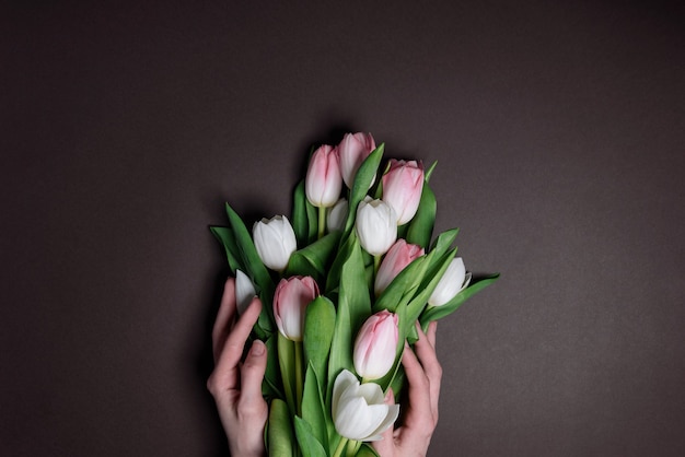 Hands with tulips. the concept of laying flowers to fallen heroes