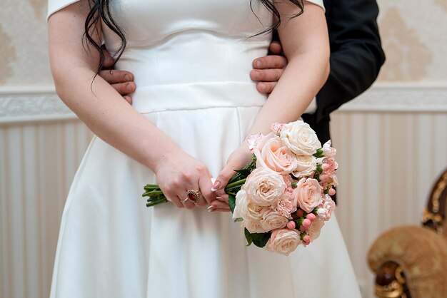 Hands with a wedding bouquet of the bride and groom dress and\
holidayxa