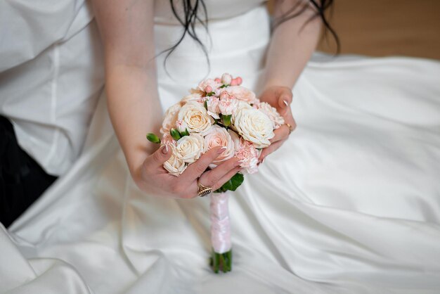 Руки со свадебным букетом платья невесты и жениха и праздникомxA