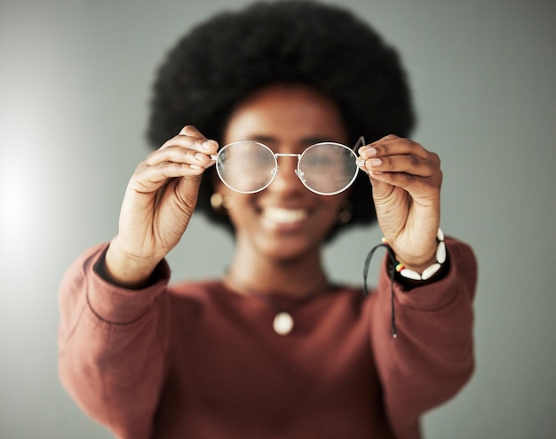 Hands woman and closeup of glasses for vision eyesight and prescription eye care in studio Person with optical frame lens choice and eyewear fashion for test healthcare assessment and optometry