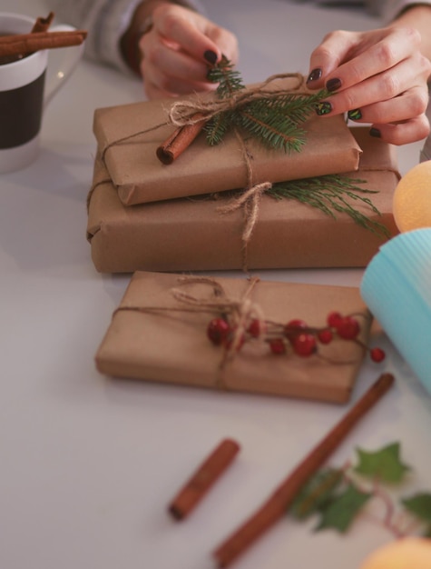 Hands of woman decorating christmas gift box Hands of woman