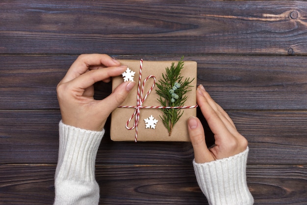 Hands of woman decorating Christmas gift box