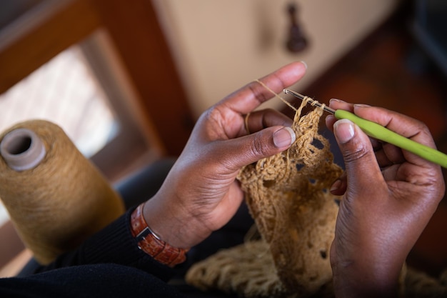 Руки женщины, занимающейся домашними делами крючком Ткань ручной работы
