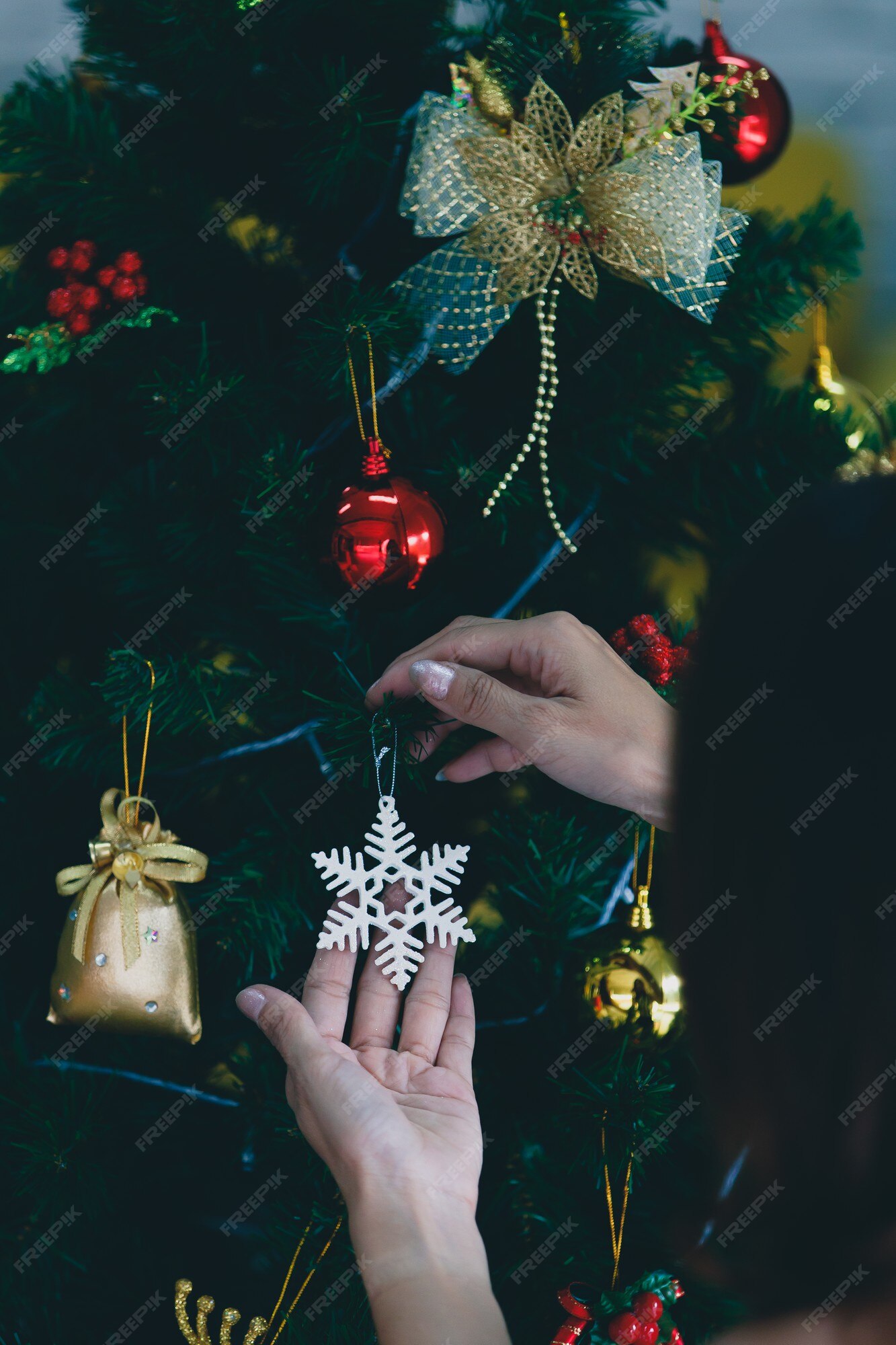 Fabric decorating bow hanging on Christmas tree with copy space in