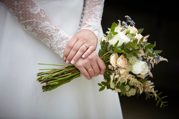 Photo hands of a woman holding a bouquet of flowers