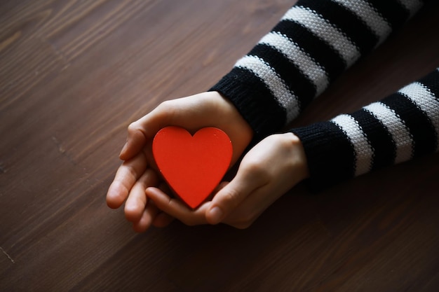 Hands of a woman holding and offering a heart shape Love health concept Selective focusCinematic effect