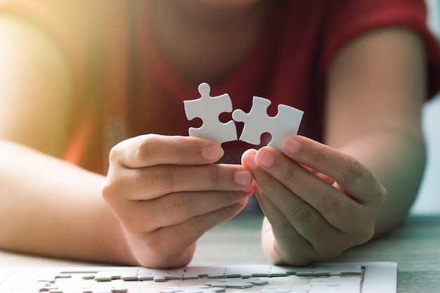 Hands of woman holding paper jigsaw puzzle