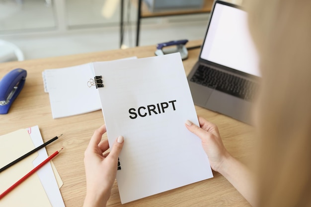 Hands of woman holding script papers for filming tv show female actress examines own role