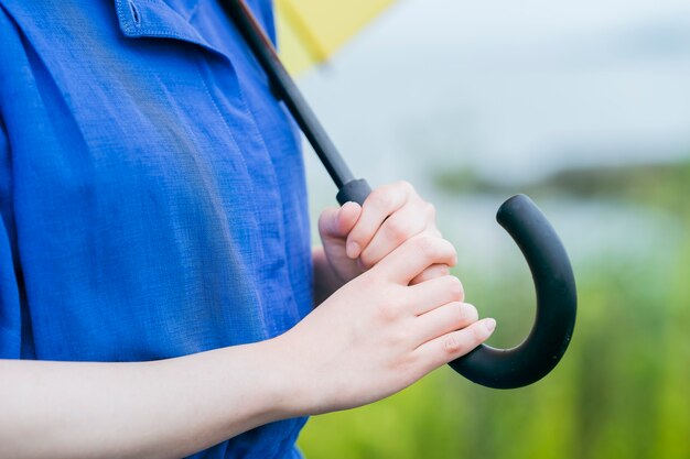 屋外で傘をさしている女性の手