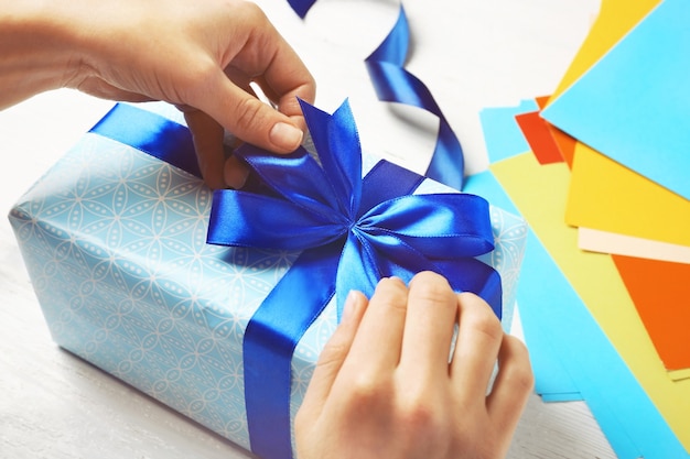 Hands of woman packing presents for holiday